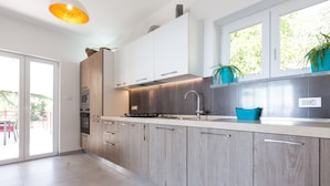 A modern kitchen with light wood cabinets, a stainless steel sink, and a built-in oven. - Villa Capra Verde - private pool, oasis of peace, 150 m as the crow flies to the sea, Opatija  (Icici)