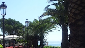 A garden with a curved pathway, palm trees, and a view of the sea. - Villa Capra Verde - private pool, oasis of peace, 150 m as the crow flies to the sea, Opatija  (Icici)