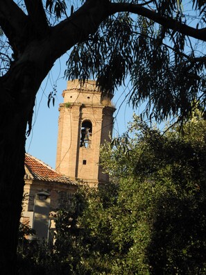 A historic stone tower with a bell, surrounded by trees and a tiled roof. - Maissonette with light, great room layout, ideal for remote working GLASFASER (Torroja del Priorat)