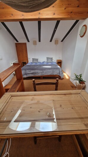 A small, cozy room with a bed, a wooden desk, and a potted plant. - Maissonette with light, great room layout, ideal for remote working GLASFASER (Torroja del Priorat)