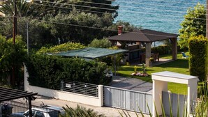 Une propriété située sur la côte, dotée d’un jardin privé, d’une piscine et offrant une vue sur la mer.