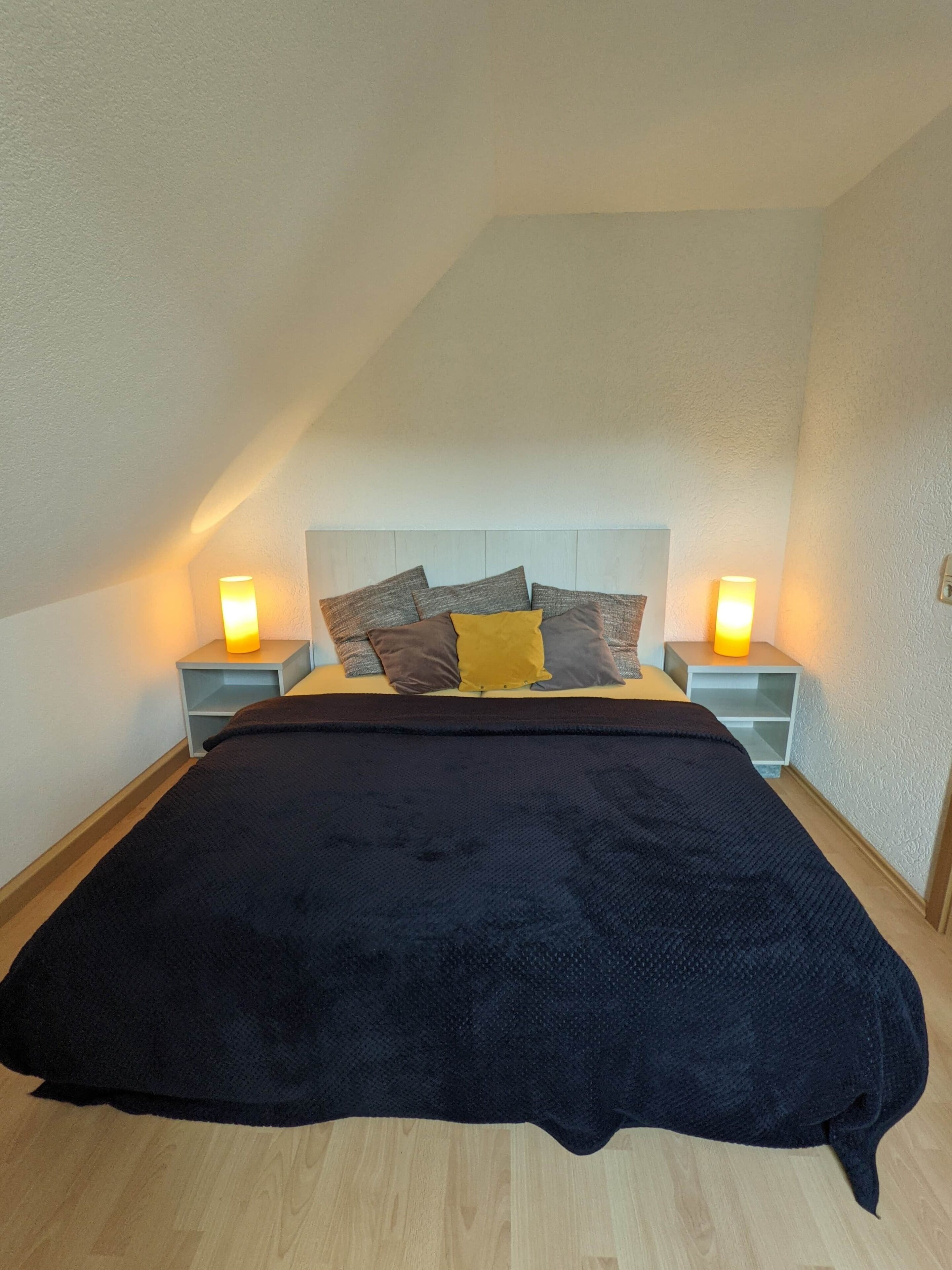 Ein Schlafzimmer mit einem Bett, zwei Nachttischen und zwei Wandlampen.