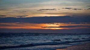 Un tramonto su una spiaggia con le onde.