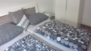 Un dormitorio con cama, almohadas y mesita de noche.