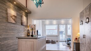 Una cocina moderna con una isla de madera, ventanas amplias y vistas al exterior.