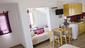 A compact living space with a bed, a dining area, and a kitchenette.