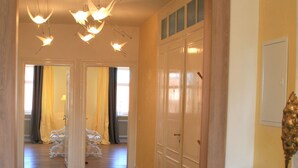 Un couloir doté d’un plancher en bois, de portes blanches et d’une vitrine.