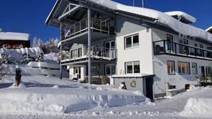 Un edificio de varios pisos con balcones, rodeado de nieve.