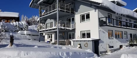 Un edificio de varios pisos con balcones, rodeado de nieve.