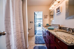 A bathroom with a vanity, sink, and mirror.