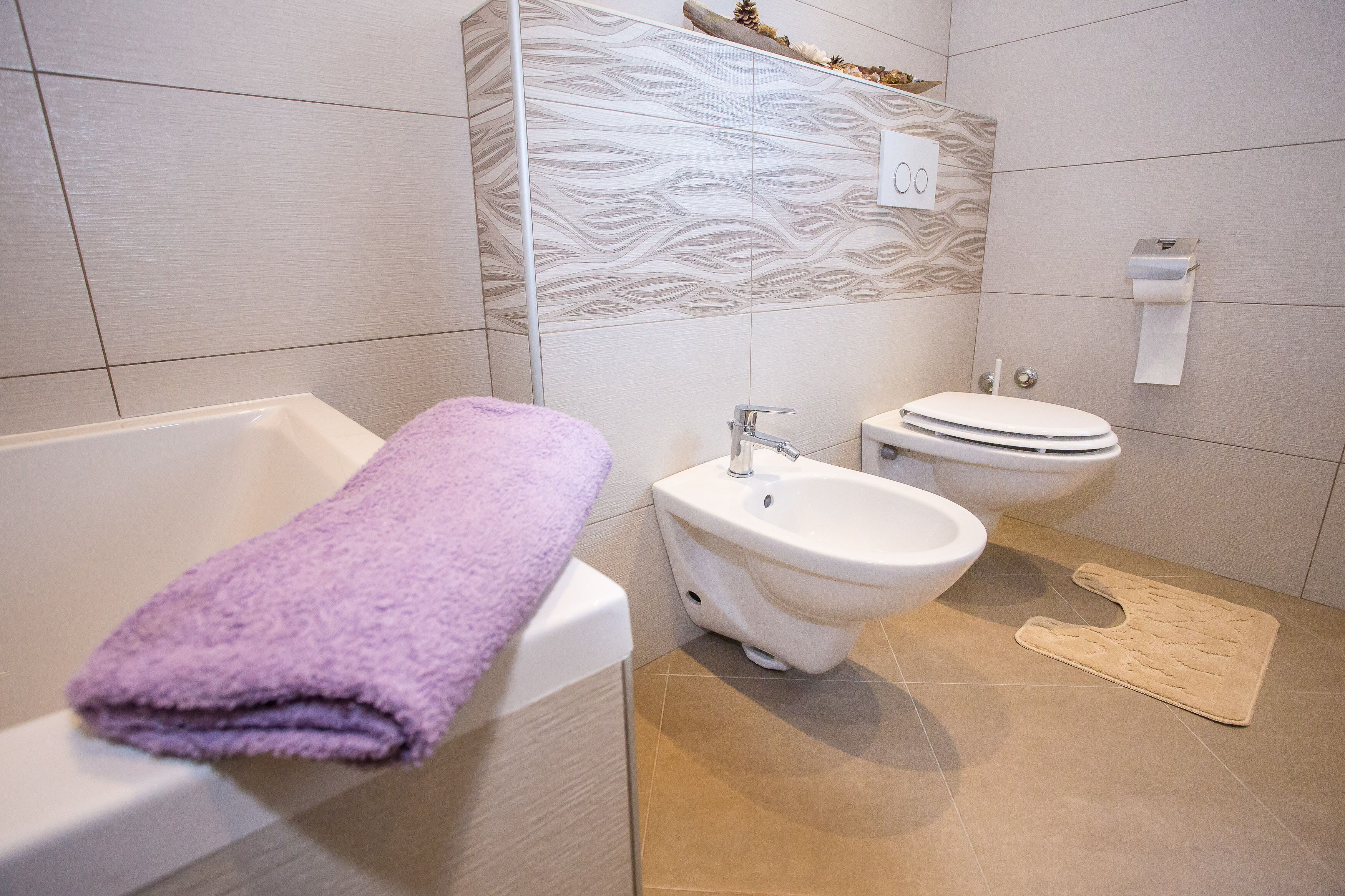 Et badeværelse med badekar, bidet og toilet.