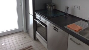 A kitchen with a built-in oven, a sink, and cabinets. - Chic bungalow (renovated in 2018) directly on the dike to the IJsselmeer / beach (Lemmer)