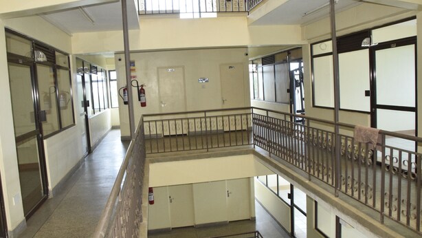 A multi-level corridor with glass doors, metal railings, and a fire extinguisher on the wall. - Quinten Hotel Kisumu (Kisumu)