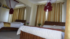 A hotel room with two beds, each with a wooden headboard, white bedding, and a red and gold curtain. - Quinten Hotel Kisumu (Kisumu)