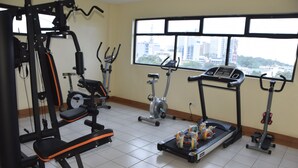 A gym with various exercise equipment, including a weight machine, treadmills, and stationary bikes. - Quinten Hotel Kisumu (Kisumu)