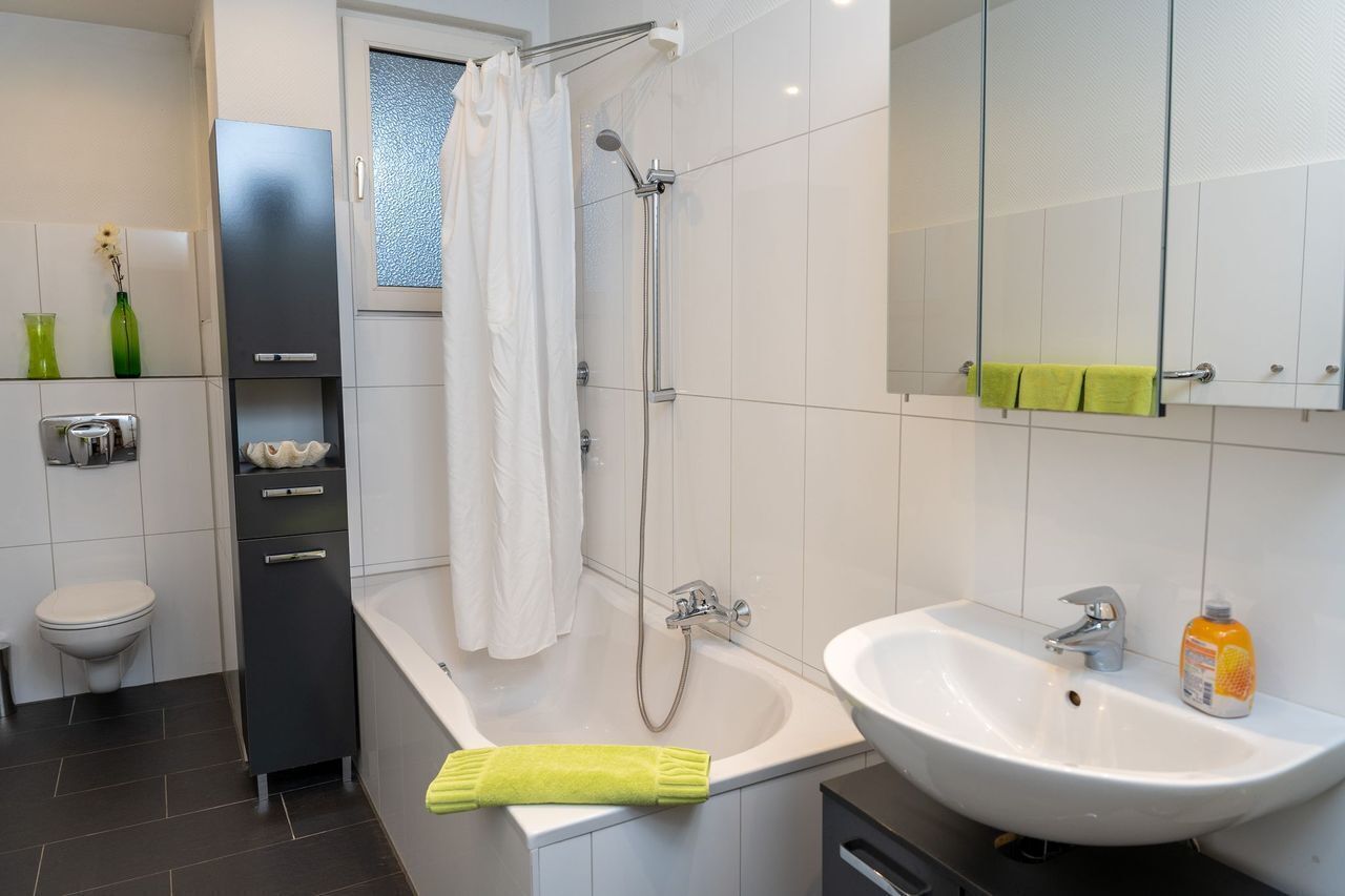 Ein modernes Badezimmer mit einer Badewanne, einem Waschbecken und einer Toilette.