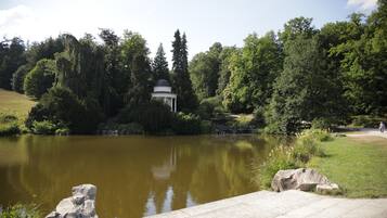 Ein friedlicher Park mit Teich, Laube und üppigem Grün.