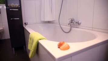 Een badkamer met een bad, een douche en een toilet.