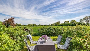 A table set outdoors with a view of a green field and trees in the background.