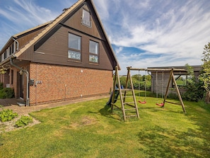 A two-story house with a brick exterior and a sloped roof.