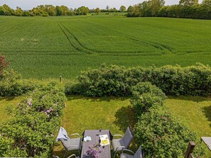 A table set outdoors with a view of a green field and trees in the background.