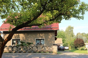 A house with a red roof, a window, and a tree in front.