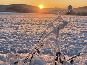 Een besneeerd landschap met een zonsondergang.