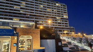 Ein großes Hotel mit mehreren Etagen, einer Statue davor und einem Schild mit der Aufschrift 'Galerie AM Meer'.