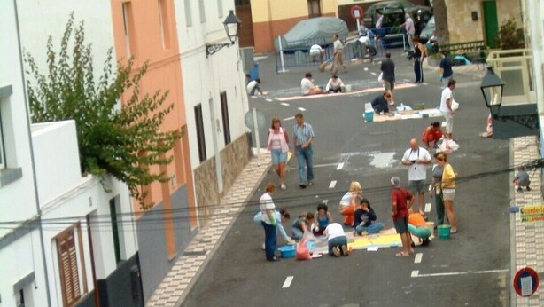 Une scène de rue où l’on voit des personnes participant à une activité de plein air, peut-être un événement communautaire ou un projet artistique.
