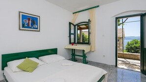 A room with a bed, a table with a mirror, and a view of the outdoors. - Apartment in Murvica with Seaview, Terrace, Air condition, WIFI (146-3) (Murvica)