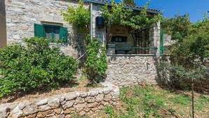 A stone building with a rustic appearance, featuring a small window with green shutters and a stone wall in front. - Apartment in Murvica with Seaview, Terrace, Air condition, WIFI (146-3) (Murvica)
