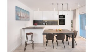 Enjoy cooking in this kitchen with a sleek island, microwave, and oven, complemented by pendant lighting and a city view.