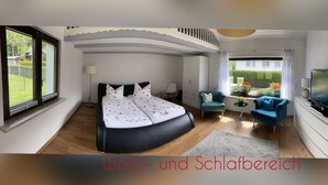 Een slaapkamer met een groot bed, een televisie en een raam met uitzicht op een tuin.