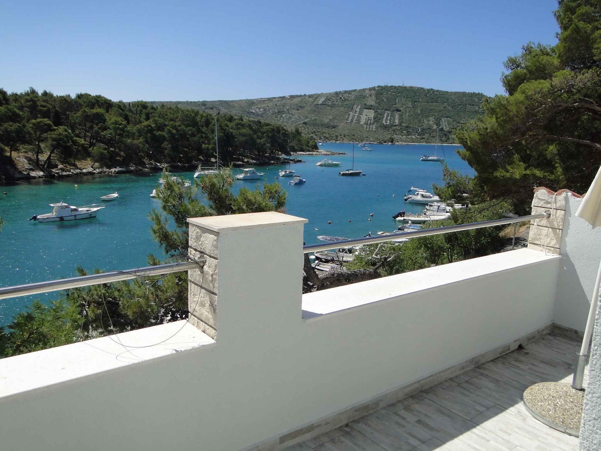 A balcony with a view of a coastal marina with boats.