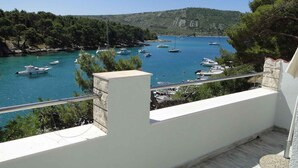 Un balcon donnant sur une marina côtière où sont amarrés des bateaux.