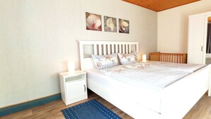 Ein Schlafzimmer mit einem Bett, einem Nachttisch, einem Kleiderschrank und einem blauen Teppich.