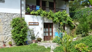 A two-story building with a stone base and a white upper section. There is a balcony with wooden railings and a sign reading "CASA TORIELLU". - Apartment in Asturian country house, close to beach (Asturien)