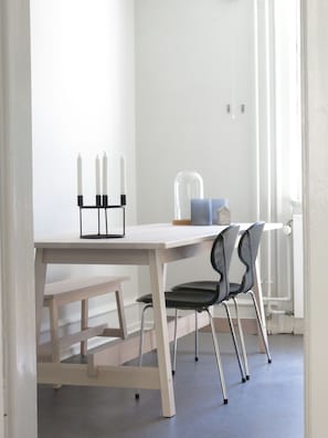 Enjoy meals in a serene dining area with a table, bench, and stylish chair.