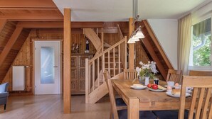 A wooden dining table with chairs, a staircase, and a view of the outdoors. - Roof top house with 3 bedrooms in Carolinensiel (90 m²) for 6-7 persons (Carolinensiel)