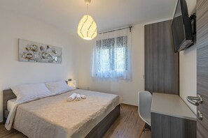 A bedroom with a bed, a desk, a chair, a TV, and a window with curtains. - Modern villa with heated private pool in a quiet location near Pula (Segotici)