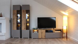 A modern living room with a flat-screen TV, wooden and grey cabinets, a fireplace, and a skylight. - modern, very spacious apartment in the immediate vicinity of the Center Parcs (Medebach)