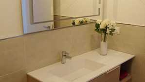 A modern bathroom with a white sink, wooden cabinet, and a mirror above it. - Nice vacation apartment in S. Alessandro-Riva del Garda. (riva del garda)