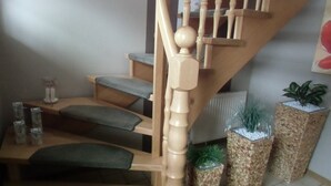 Een houten trap met een leuning, beklede treden en decoratieve plantenbakken.