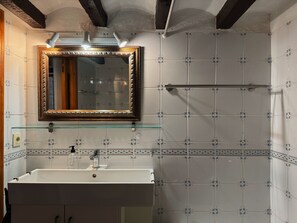 A bathroom with a white sink, a mirror with a decorative frame, and patterned tiles. - Holiday house with pool, garden, ca. 1 km to beach, tranquil, south-facing (Jávea)