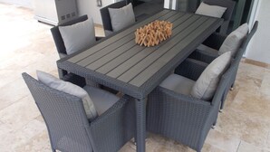 A rectangular outdoor dining table with six grey wicker chairs, each with a cushion. - Modern villa with large pool! Free Wifi! (Venice)