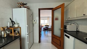 Una cocina equipada con refrigerador, microondas y armarios de madera.