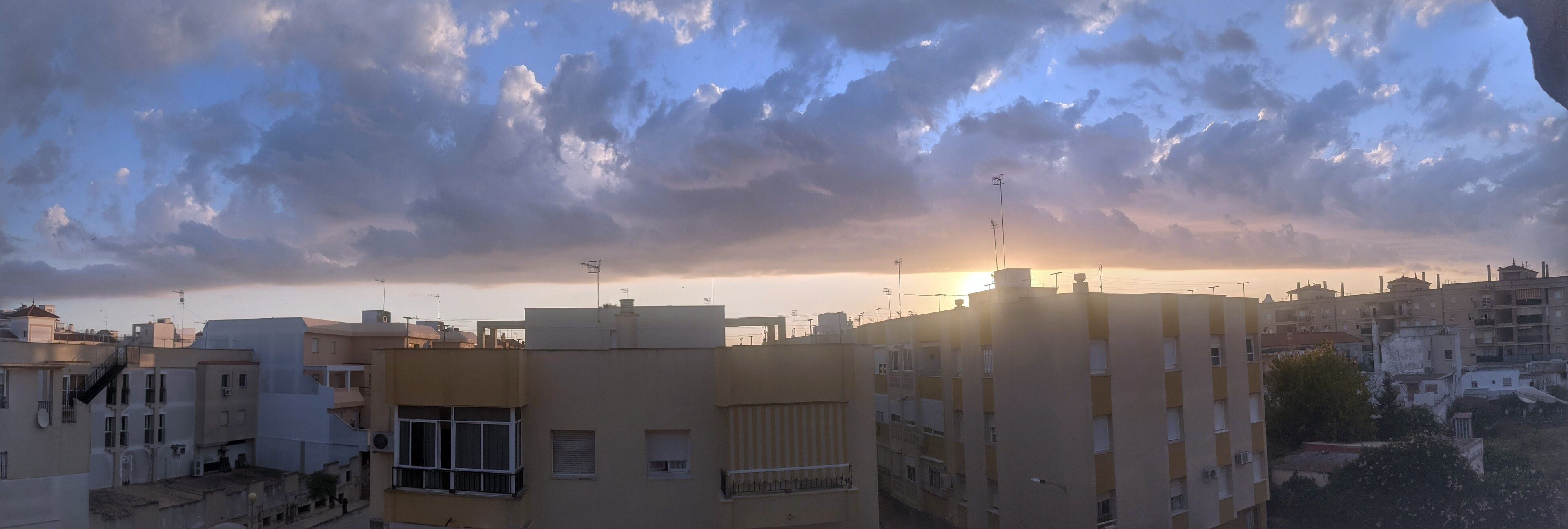 Une vue d’une ville au coucher du soleil, avec ses bâtiments.