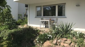 A modern building with a balcony, a table with chairs, and a garden with rocks and plants. - Close to the city live in the countryside with good access (Heidelberg)