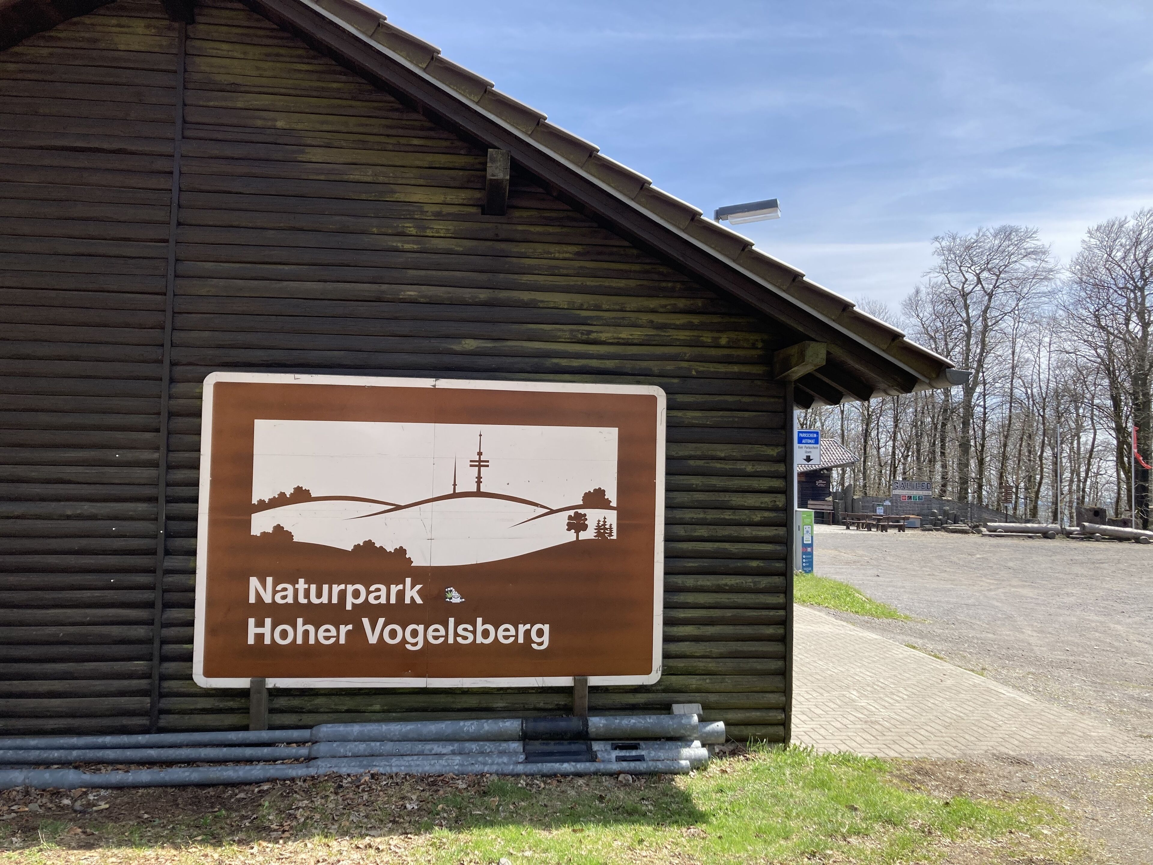 Señal de Naturpark Hoher Vogelsberg con una ilustración del paisaje.