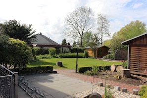A courtyard with a paved walkway, benches, and a wooden building.
